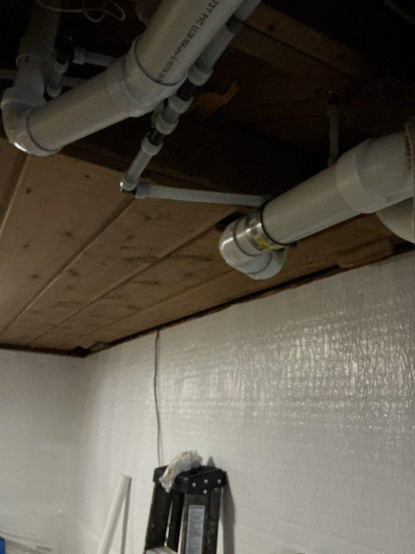 Completed comprehensive drain and water repipe project in basement utility area, installing new PVC drainage lines and water supply piping along ceiling joists. Successfully connected all plumbing to existing water heater and filtration system while ensuring proper alignment and secure fastening of all components throughout the system.