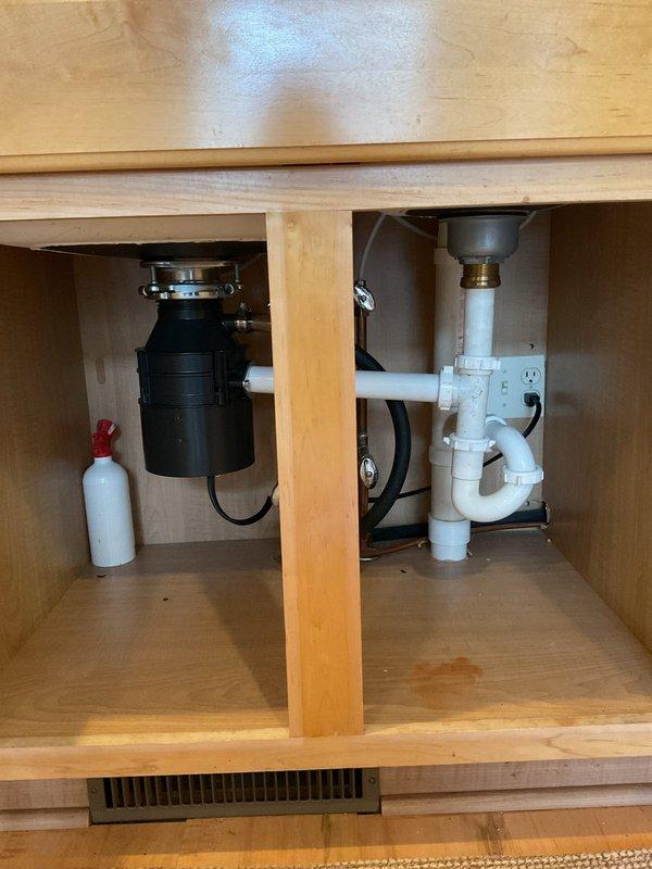 Resolved kitchen sink leak by identifying and repairing faulty connection in the PVC drain assembly. Inspected entire under-sink plumbing system including garbage disposal and P-trap for additional issues, and confirmed proper function with water test after repair.