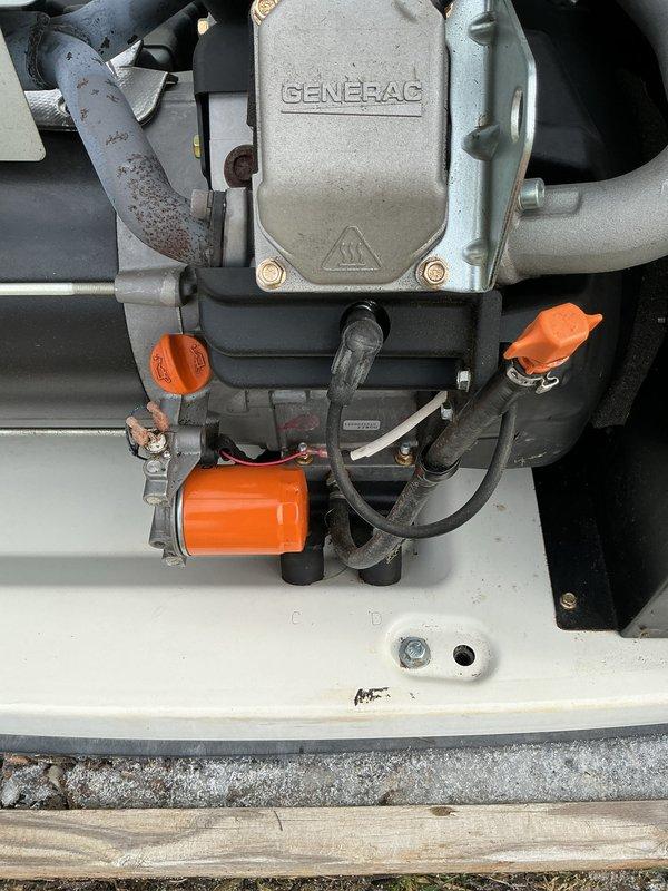 Conducted scheduled 5-year tune-up service on Generac generator system. Inspected engine components including oil filter, fuel connections, and air intake assembly, noting minor surface corrosion on exhaust piping but confirming overall system functionality. Completed preventative maintenance according to manufacturer specifications with photographic documentation of work performed.