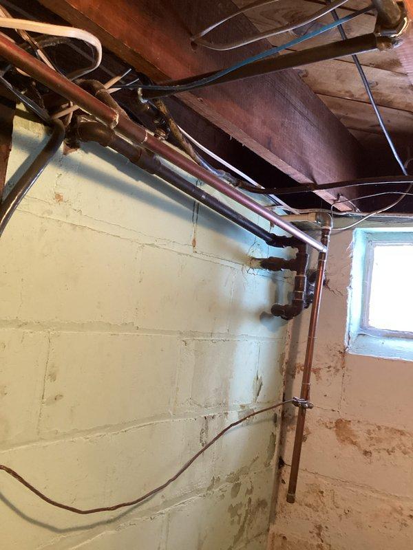 Conducted site assessment for client requesting installation of grab bars, Toto Drake toilet installation, reinstallation of toilet seat with riser, and tankless water heater system. Inspection of basement revealed aging copper plumbing infrastructure with evidence of moisture issues on concrete block walls, and evaluation of existing plumbing connections for compatibility with requested on-demand water heating system.