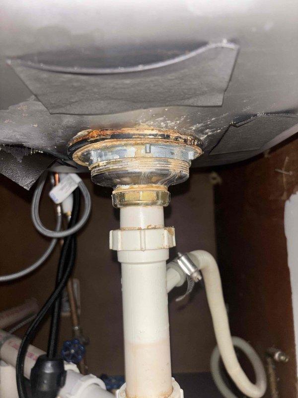 Responded to plumbing leak service call. Repaired corroded sink drain assembly with significant mineral buildup that was causing leakage under faucet. Additionally, installed customer-provided toilet seat replacement as requested.