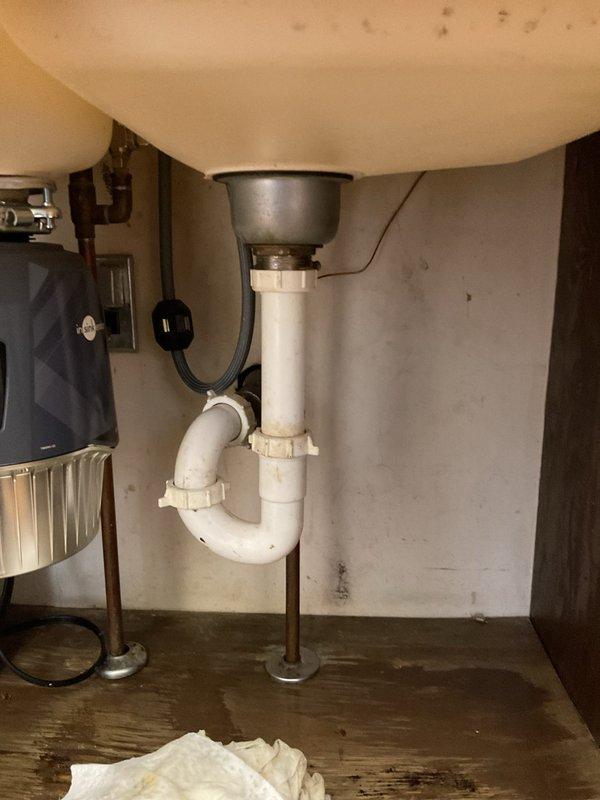 Responded to service call for kitchen sink drain clog persisting for approximately two days in a 1963 residence. Inspected the double-basin kitchen sink and associated PVC P-trap assembly. Successfully cleared blockage in drainage system, restoring proper functionality to the kitchen sink.