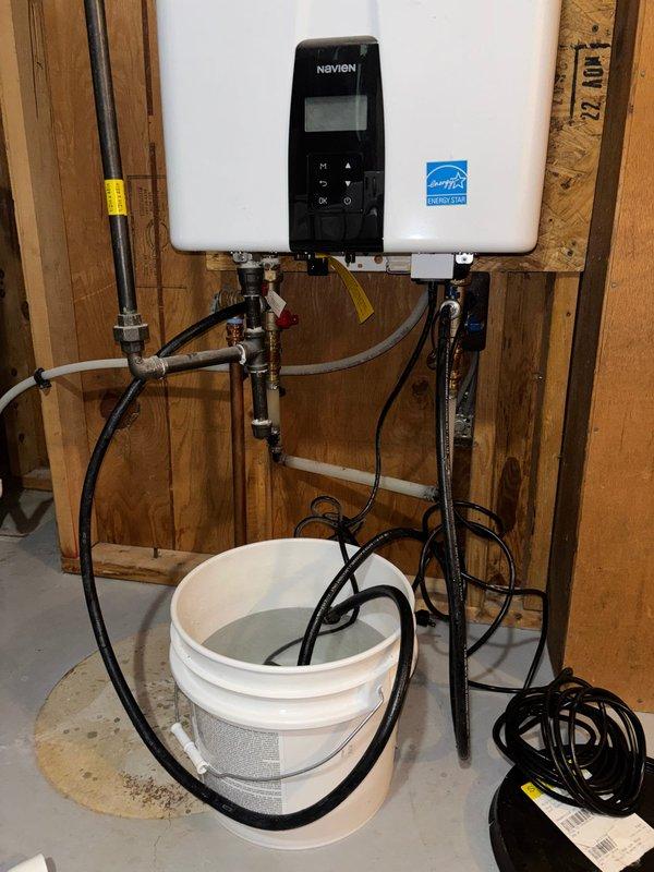 Performed scheduled tune-up on Navien tankless water heater. Descaled unit using circulation pump and cleaning solution to remove mineral buildup from heat exchanger. Inspected all connections, verified proper venting, and confirmed system was operating at manufacturer specifications after service.