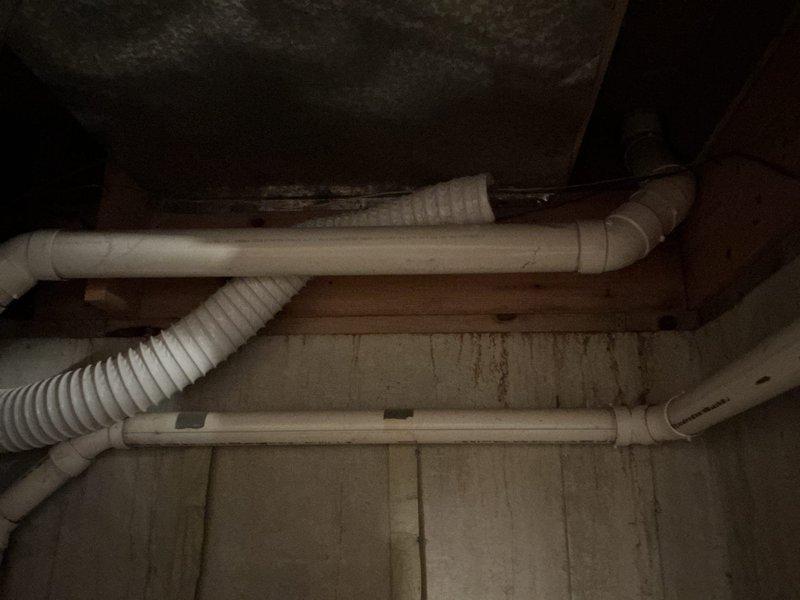 Conducted electrical inspection of breaker panel in utility area, documenting panel condition and circuit configuration. Panel showed proper labeling with multiple marked breakers. Also noted adjacent plumbing system with PVC drainage pipes showing signs of previous moisture exposure on surrounding wood surfaces, though no active leaks were detected.