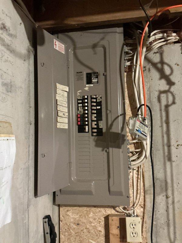 Conducted electrical inspection of breaker panel in utility area, documenting panel condition and circuit configuration. Panel showed proper labeling with multiple marked breakers. Also noted adjacent plumbing system with PVC drainage pipes showing signs of previous moisture exposure on surrounding wood surfaces, though no active leaks were detected.