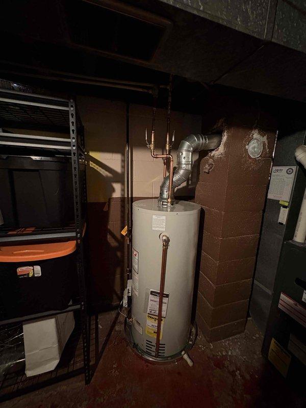 Completed installation of a new water heater in basement utility room, including proper connection of copper supply lines and installation of metal ventilation piping. Verified proper venting through roof-mounted chimney stack to ensure safe exhaust discharge and system functionality.