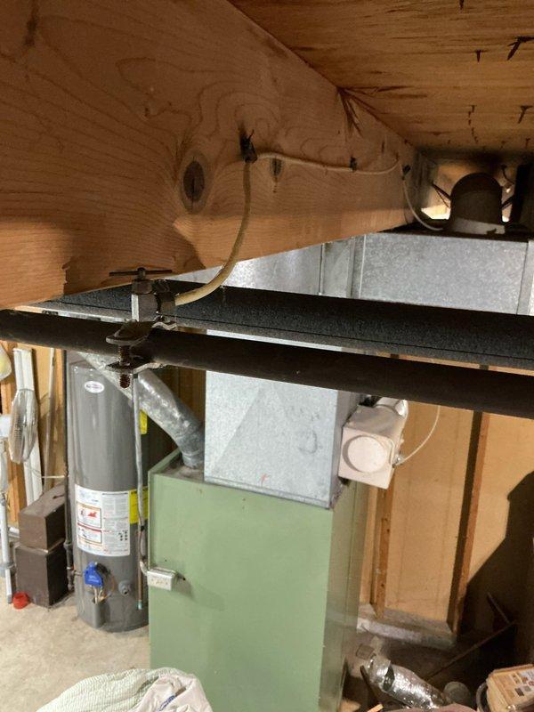 Conducted comprehensive assessment of 16-year-old furnace system and property for potential replacement and AC addition. Observed aging mint-green furnace unit with existing ductwork in basement utility area. Documented current installation configuration including ventilation connections and available space for new equipment to prepare accurate system replacement and AC installation quote.