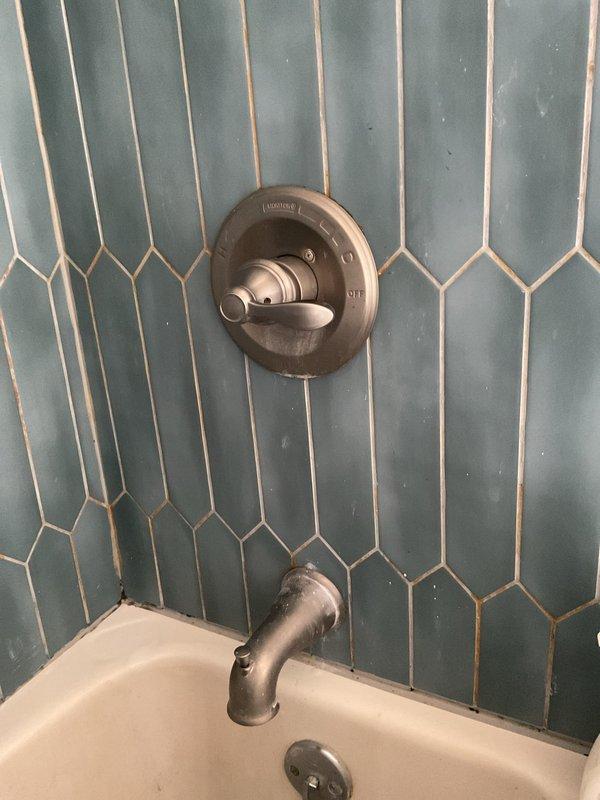 Completed quoted repair to replace shower shut off valve and cartridge. Removed damaged tile to access valve assembly, then installed new components and verified proper water flow. Finished installation with brushed nickel trim kit including single lever control handle and tub spout, restoring full functionality to the shower system.