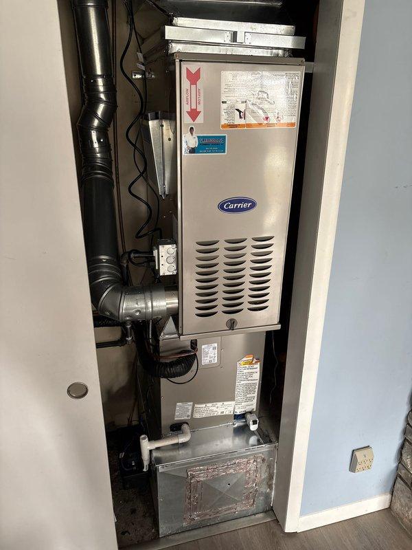 Successfully completed installation of a new Carrier furnace and AC system. The outdoor condenser was properly placed on a concrete pad with appropriate electrical conduit and refrigerant line connections. Indoor furnace unit was installed with proper ductwork connections and all required safety labels in place.