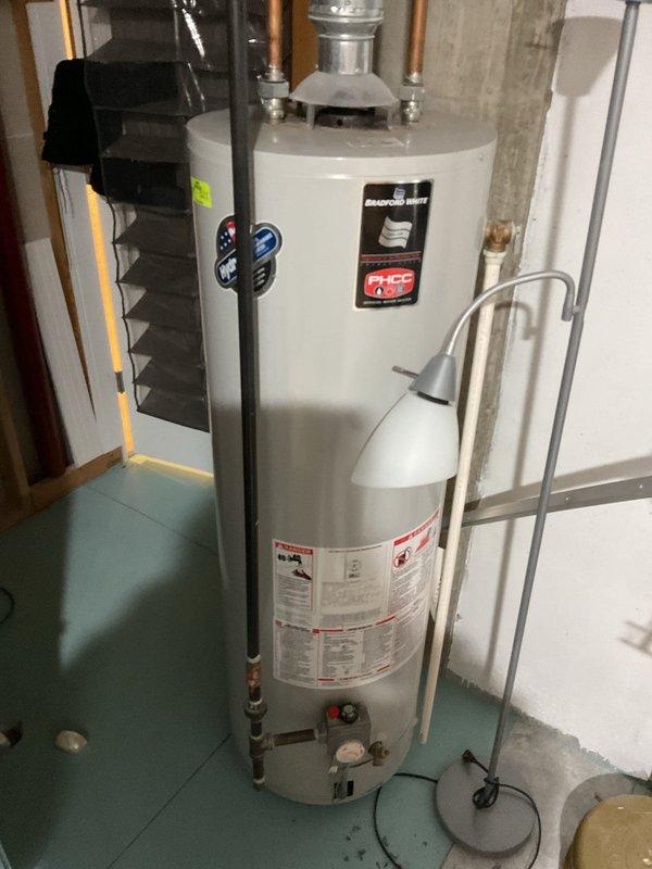 Conducted water heater replacement estimate for client's father (non-English speaking) at residence. Inspected existing water heater system, including connected copper piping, ventilation components, and current installation configuration in basement utility area. Photos documented the current unit and surrounding mechanical infrastructure for accurate quote preparation.