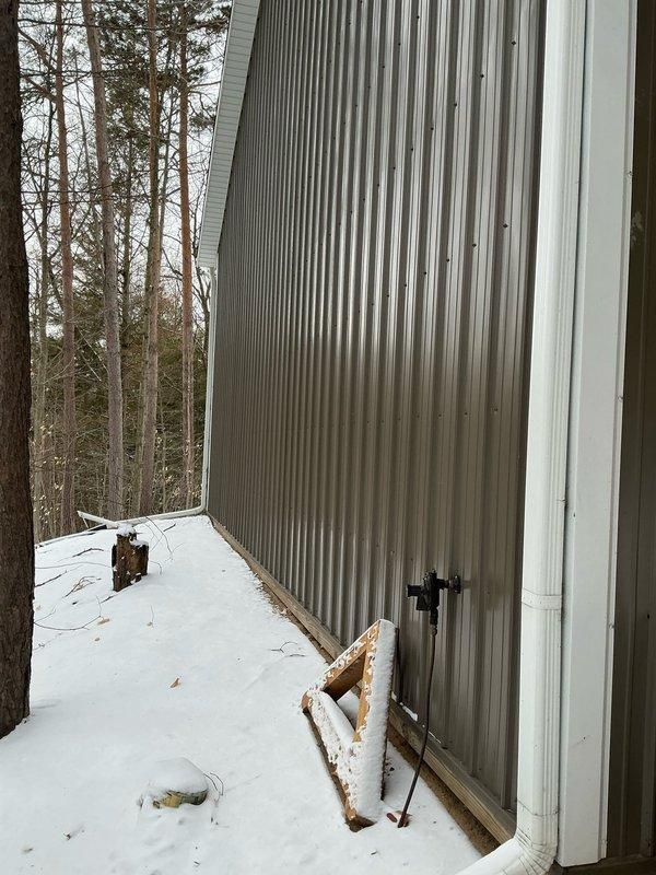 Conducted site assessment for mini-split installation in a 16' x 40' x 14' insulated pole barn. Inspected electrical panel capacity and documented spray foam insulation throughout the structure. Evaluated exterior wall conditions for potential condenser placement, noting metal corrugated siding and surrounding environmental factors.