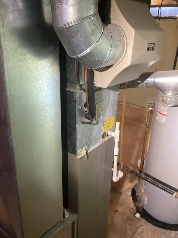 Performed comprehensive furnace tune-up on 20-year-old residential HVAC system located in basement utility room. Inspected and serviced aging furnace unit with attached metal ductwork, cleaned components, and verified proper operation of the system which showed signs of regular wear. Confirmed 20×25×5 filter dimensions and replacement requirements during maintenance.