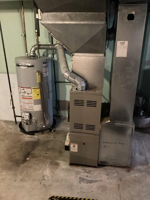 Performed comprehensive furnace tune-up on 20-year-old residential HVAC system located in basement utility room. Inspected and serviced aging furnace unit with attached metal ductwork, cleaned components, and verified proper operation of the system which showed signs of regular wear. Confirmed 20×25×5 filter dimensions and replacement requirements during maintenance.