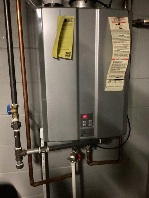 Inspected 12+ year old Ruud tankless water heater experiencing intermittent hot water failure, particularly during evening usage. Discovered mineral buildup in heat exchanger and partially clogged inlet filter restricting water flow. Performed comprehensive descaling service and cleaned filter assembly to restore proper operation and heat transfer efficiency.