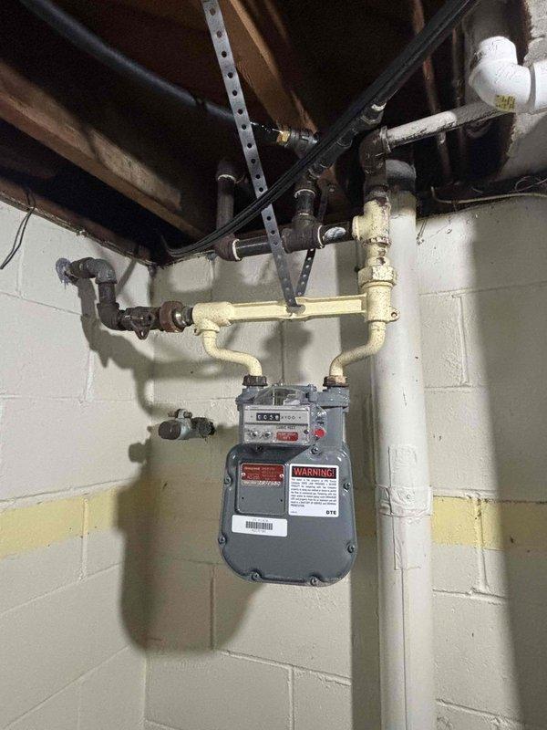 Performed gas line replacement service at a 70-year-old residence, connecting whole home generator to existing gas supply system. Inspection revealed aging infrastructure with various repairs and additions over time, including mixed piping materials (black iron and PVC components) and supporting brackets. Work included proper installation and securing of gas lines in the utility area/crawlspace, ensuring all connections were leak-free and compliant with current gas safety standards.