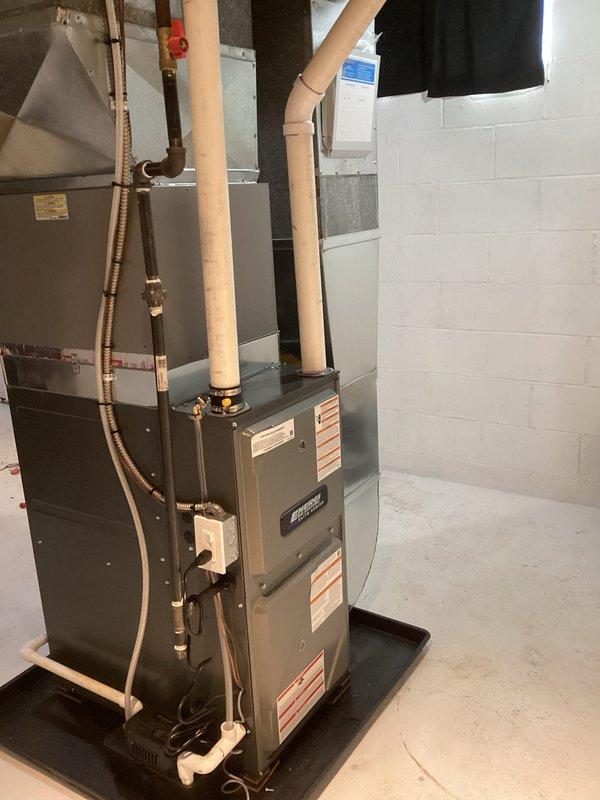 Successfully completed installation of new furnace and water heater in basement utility room. New furnace was properly mounted on black base pad with all required PVC venting, copper lines, and electrical connections installed to code. System was tested for proper operation with all connections secure and labeled.