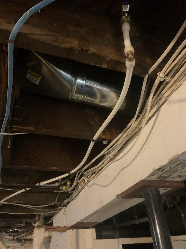 Completed inspection of exposed HVAC ductwork in unfinished ceiling area. Examined galvanized metal ducting system including elbow joints, connections to main trunk lines, and mounting to wooden joists. Also inspected adjacent PVC plumbing pipes and electrical cables for potential interference issues.
