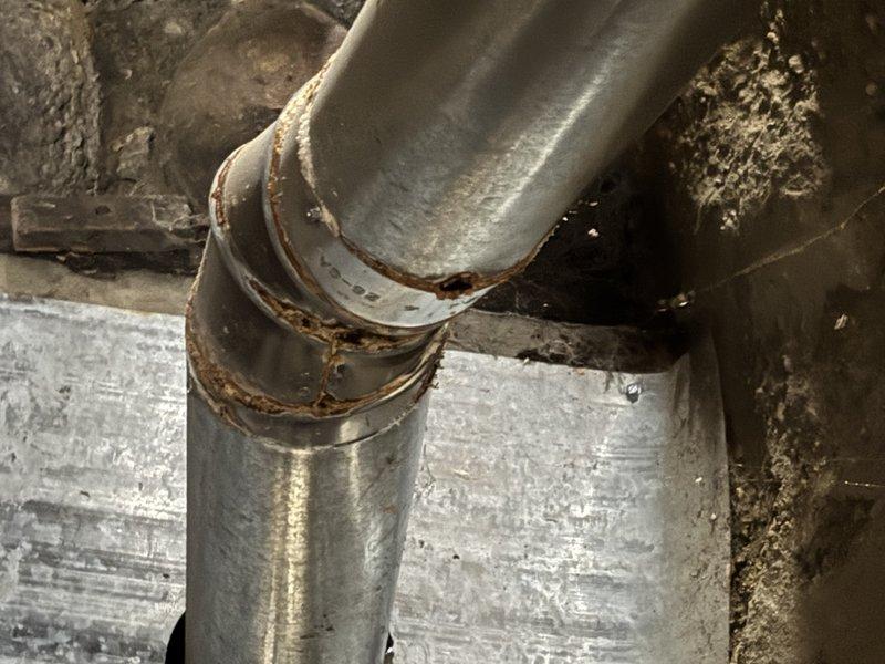 Responded to service call for a 9-year-old heating system that was cutting out intermittently and eventually stopped heating and blowing completely. Inspection revealed significant corrosion and rust formation at pipe joints in the system, with visible deterioration around connection points and a compromised welded seam showing potential leakage. Documented extensive metal deterioration with photographic evidence for comprehensive repair planning.
