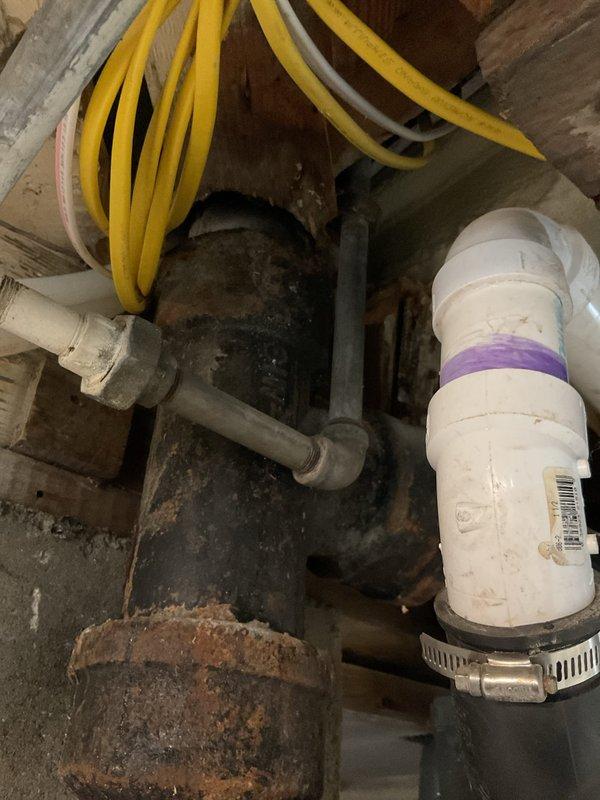 Responded to emergency call for active sewage leak in basement when toilet was flushed. Inspection revealed severely corroded cast iron drain pipe with significant rust deterioration at connection points. Replaced damaged section with new PVC pipe, properly secured with metal clamps and sealed all joints to restore proper drainage function and stop active leak.