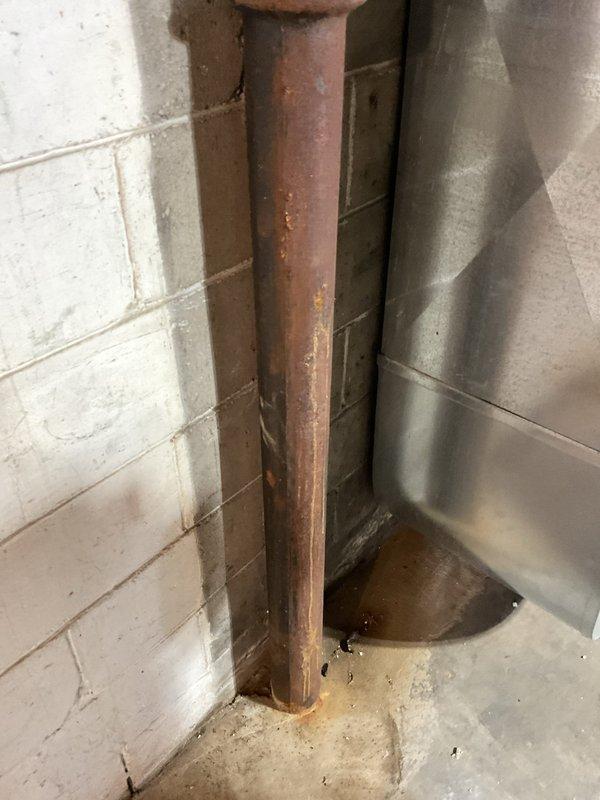 Responded to emergency call for active sewage leak in basement when toilet was flushed. Inspection revealed severely corroded cast iron drain pipe with significant rust deterioration at connection points. Replaced damaged section with new PVC pipe, properly secured with metal clamps and sealed all joints to restore proper drainage function and stop active leak.