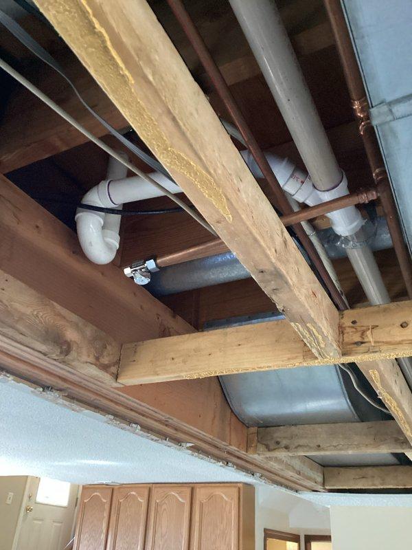 Completed 4 hours of kitchen rough-in plumbing work, installing PVC drainage system with multiple joints and connections. Installed copper supply lines between floor joists and verified proper P-trap configuration for kitchen fixtures. Will return to complete remaining kitchen plumbing installation.