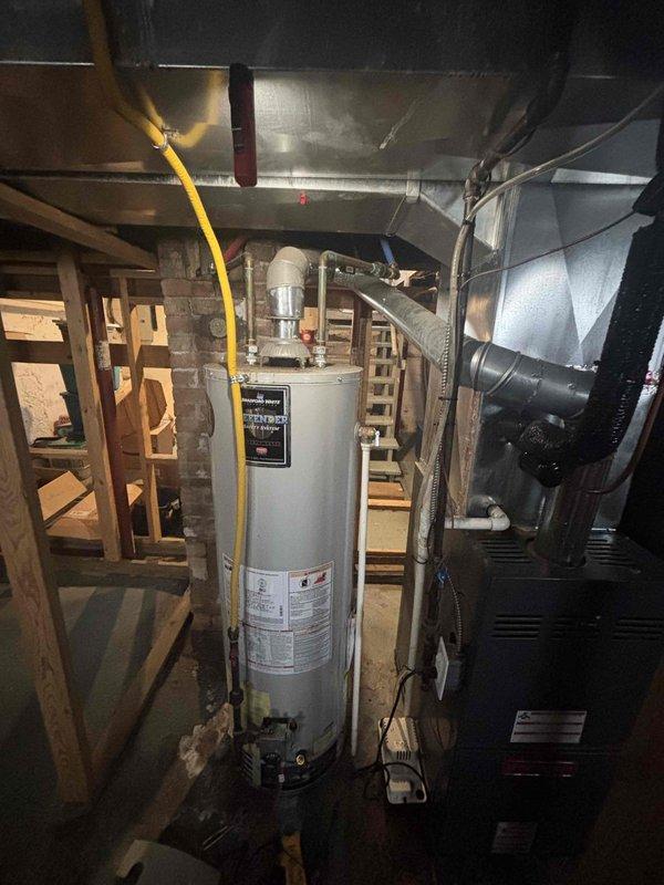 Responded to no hot water call and found aging water heater with active leak at base. Diagnosed terminal tank failure with visible corrosion and water accumulation around base. Recommended complete replacement due to age and deterioration of unit.