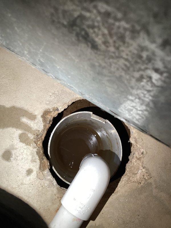 Responded to service call for a clogged drain between the furnace condensation drain and sewer line in the basement of a side-by-side condo. Inspected the PVC pipe connection and drainage system, documented the condition with photos, and cleared the blockage that had been causing drainage issues for 4-5 days, restoring proper condensate flow.