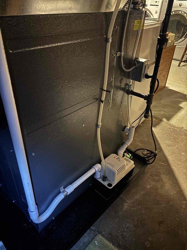 Responded to an inspector correction regarding a missing discharge hose clamp at the pump. Located the issue, installed the required hose clamp on the clear flexible discharge hose to properly secure the connection to the condensate pump, ensuring compliance with installation standards.