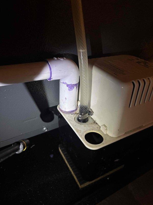 Responded to an inspector correction regarding a missing discharge hose clamp at the pump. Located the issue, installed the required hose clamp on the clear flexible discharge hose to properly secure the connection to the condensate pump, ensuring compliance with installation standards.