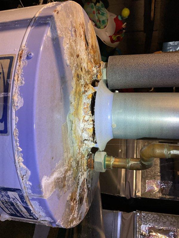 Performed annual heating maintenance on 7-year-old Goodman furnace. Observed significant corrosion and mineral buildup on water heater with deterioration of outer casing. Noted rust accumulation on water heater top surface and cobwebs throughout ductwork, suggesting ventilation system requires attention.