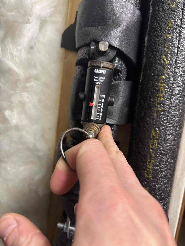 Returned to complete geothermal system service that previous technician was unable to resolve. Retrieved necessary tools from shop as instructed, then adjusted Caleffi balancing valve on insulated pipe and verified system operation using electronic diagnostic display.