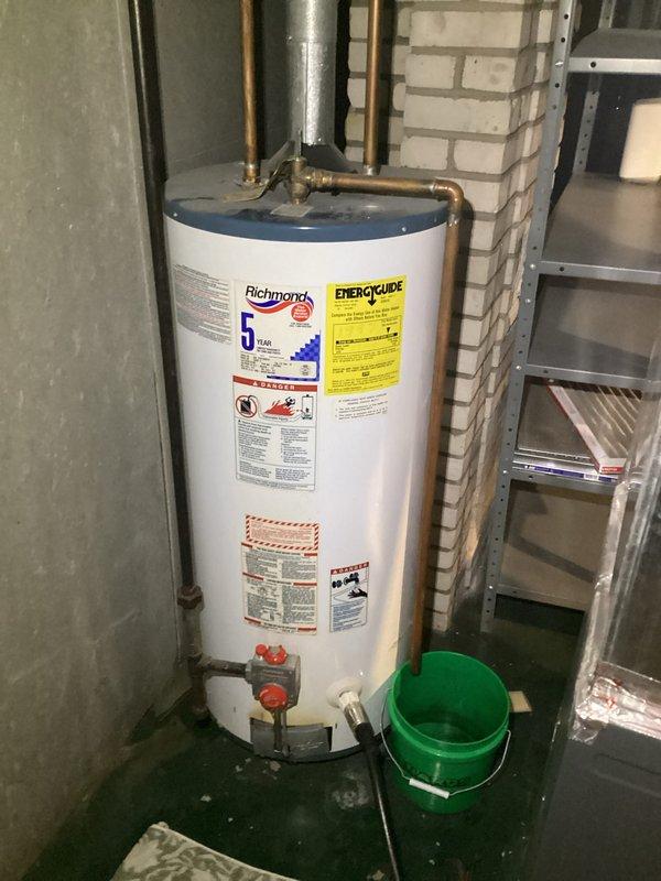 Performed water heater replacement estimate for CWOW. Inspected existing Richmond 5-gallon unit showing signs of age. Documented copper supply lines, nearby PVC drainage, and current installation configuration in basement utility area. Photos taken of existing plumbing network and water heater to support estimate preparation.
