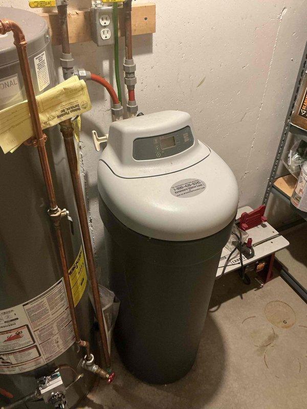 Conducted estimate for water softener installation in 25-year-old home with existing plumbing infrastructure. Assessed current setup including copper supply lines, water heater connections, and available utility space in basement area. Documented existing conditions with photos to provide accurate system specifications for replacement of aging water conditioning equipment.
