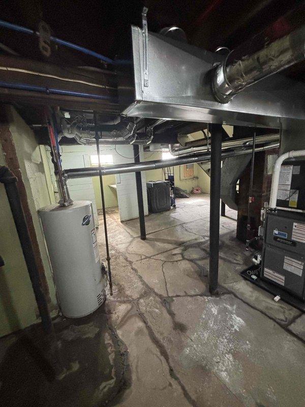 Responded to an inspector correction for a partially approved inspection. Verified the chimney liner was still in its packaging and not properly installed as required. Documented the utility area with photographs showing the installation site, including the basement mechanical room with exposed ductwork, water heater, and HVAC components where the liner should have been installed.