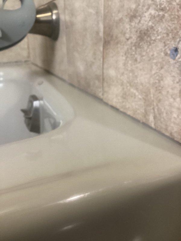 Completed plumbing project involving application of new silicone sealant around entire bathtub perimeter to prevent water intrusion. Installed exterior water access by connecting new outdoor faucet from kitchen sink plumbing through exterior wall. Successfully replaced shower cartridge to resolve water flow/temperature control issues, restoring proper functionality.