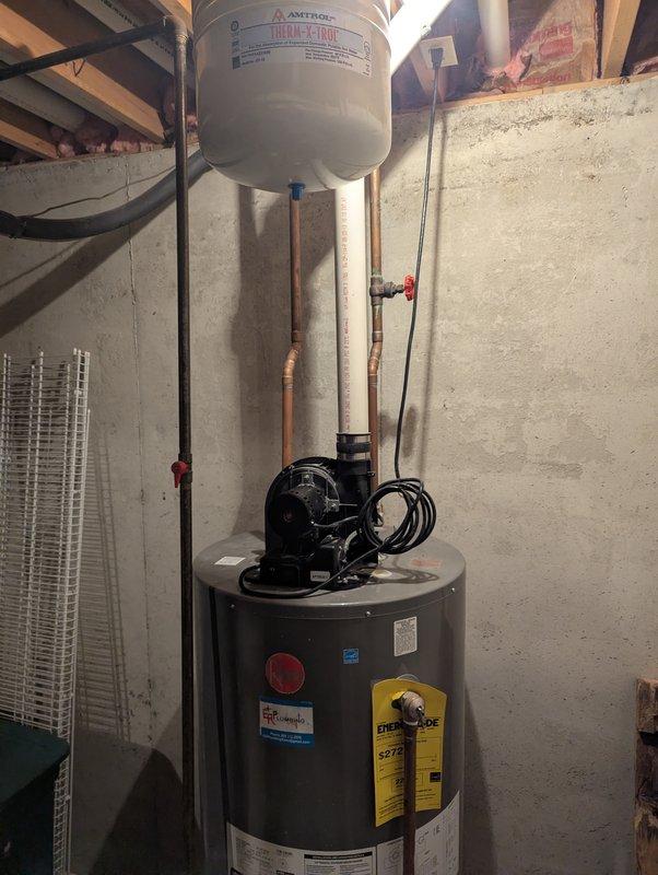 Diagnosed 13-year-old Rheem water heater that was not heating and had developed a leak, creating a puddle underneath the unit. Inspection revealed extensive corrosion and rust at the drain assembly, indicating tank failure. Recommended complete replacement of the water heater due to age and deteriorated condition.