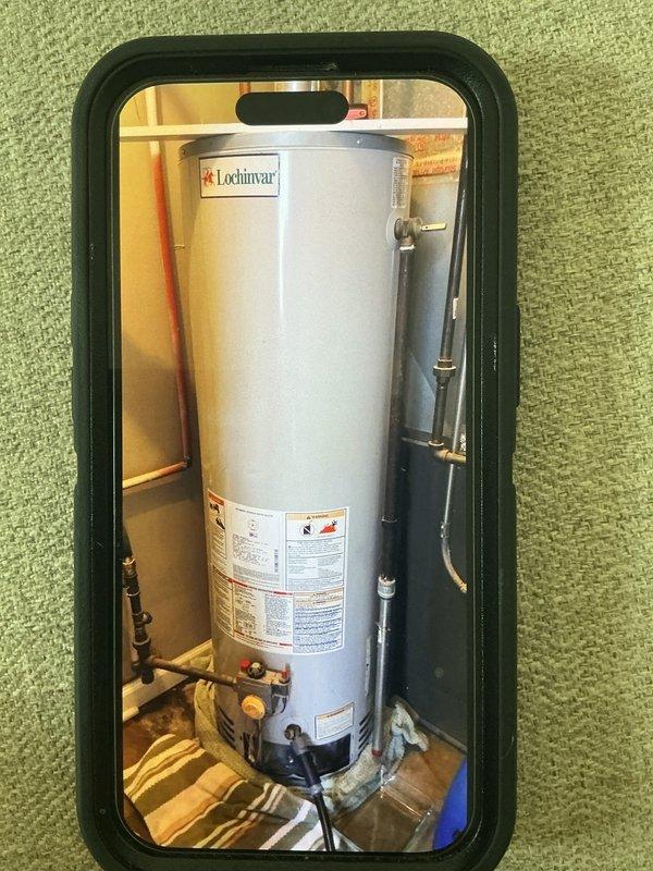 # Water Heater Problem Service Report

Responded to service call for water heater issue. Upon arrival, inspected Lochinvar residential water heater unit installed in utility space. Conducted visual assessment of the installation, including examination of copper supply line connections, brass shut-off valves, and venting system. Verified proper clearances and reviewed manufacturer specifications displayed on unit labeling. Documented existing installation configuration with photographs showing piping connections, vent pipe routing, and overall equipment condition. All connections appeared secure with no visible signs of leakage at fittings or valve assemblies. Unit operational status confirmed and installation meets code requirements.