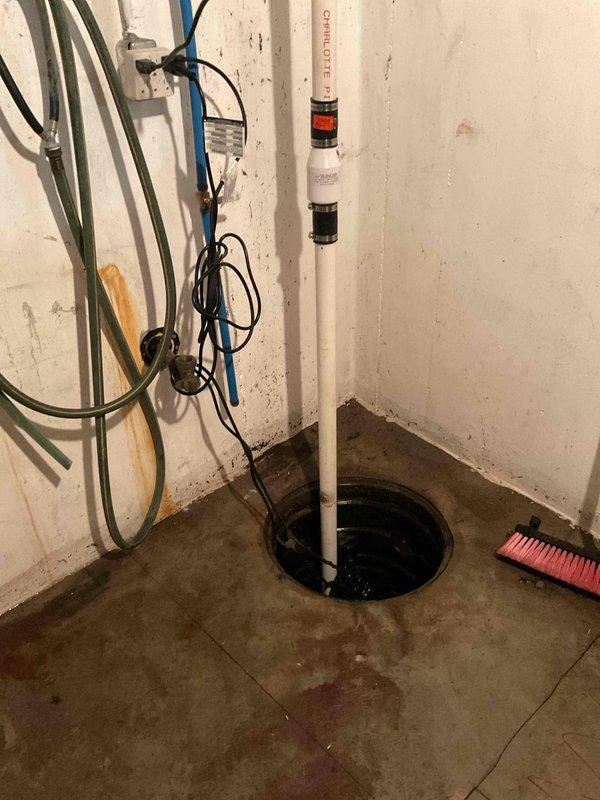 # Service Report: Sump Pump Failure

Responded to a failed sump pump system in basement utility area. Upon arrival, found the sump pit filled with standing water and the pump inoperative. Removed the failed sump pump unit from the pit and assessed the existing Charlotte PVC discharge piping and check valve assembly. Installed a new replacement sump pump, reconnected to the existing vertical discharge line, and verified proper check valve operation to prevent backflow. Tested the new pump for proper cycling, float switch activation, and adequate discharge flow through the wall-mounted piping system. Confirmed all electrical connections were secure and the unit was functioning properly before completing the service call.