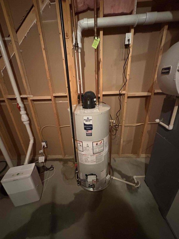 Completed installation of a Bradford White 40-gallon natural gas water heater in the mechanical room. Unit was properly connected to existing copper supply lines, gas line, and venting system, with pressure relief valve and discharge pipe installed per code. All connections were tested and verified operational, payment collected, and installation photos documented for service records.