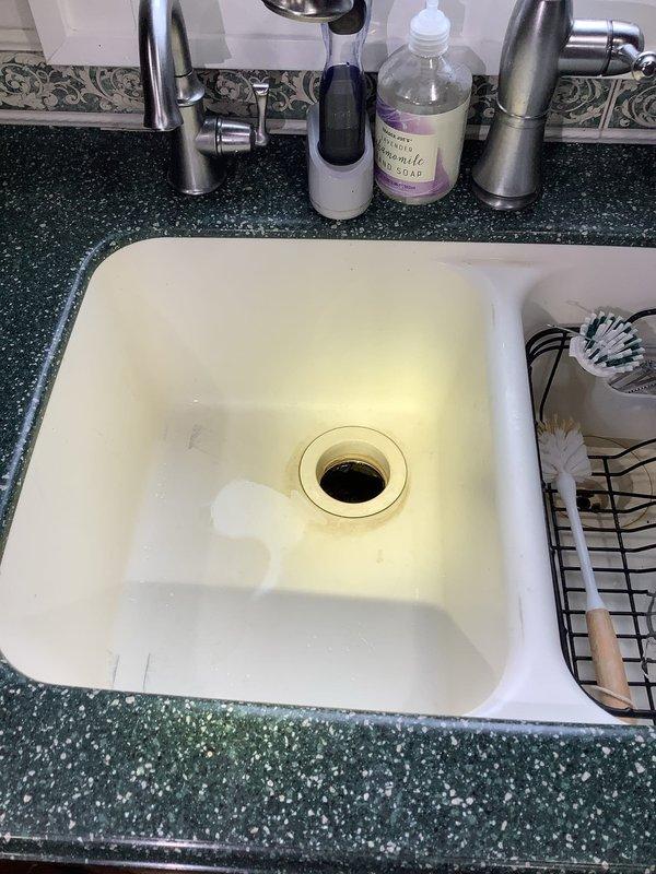 # Service Report: Garbage Disposal Repair

Responded to service call for non-operational garbage disposal unit. Upon arrival, inspected kitchen sink area and identified disposal system beneath sink with dark green granite countertop. Accessed disposal unit from basement crawl space to assess mechanical and electrical components. Examined disposal mounting assembly, drain connections, and associated plumbing infrastructure including corroded supply lines and drainage pipes. Diagnosed failure point in disposal system and performed necessary repairs to restore unit to proper working condition. Tested disposal operation to verify functionality and confirmed proper drainage with no leaks at connection points. Unit now operating normally with adequate grinding performance and proper waste discharge.