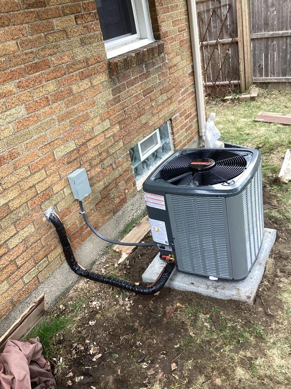 # AC Installation Summary

Successfully completed installation of new residential air conditioning system. Unit installed on concrete pad against exterior brick wall with proper electrical connection via conduit to junction box. System tested and confirmed operational upon completion.

# Detailed Service Description

Performed complete installation of new HVAC air conditioning unit at residential property. The outdoor condensing unit was positioned on a level concrete pad adjacent to the exterior brick wall, ensuring proper clearance and accessibility for future maintenance. 

Electrical connections were completed using black flexible conduit running from the unit to a wall-mounted junction box, providing secure and code-compliant power supply to the system. All electrical work was performed according to manufacturer specifications and local electrical codes.

The installation included proper mounting and leveling of the unit on the concrete pad to prevent vibration and ensure optimal 