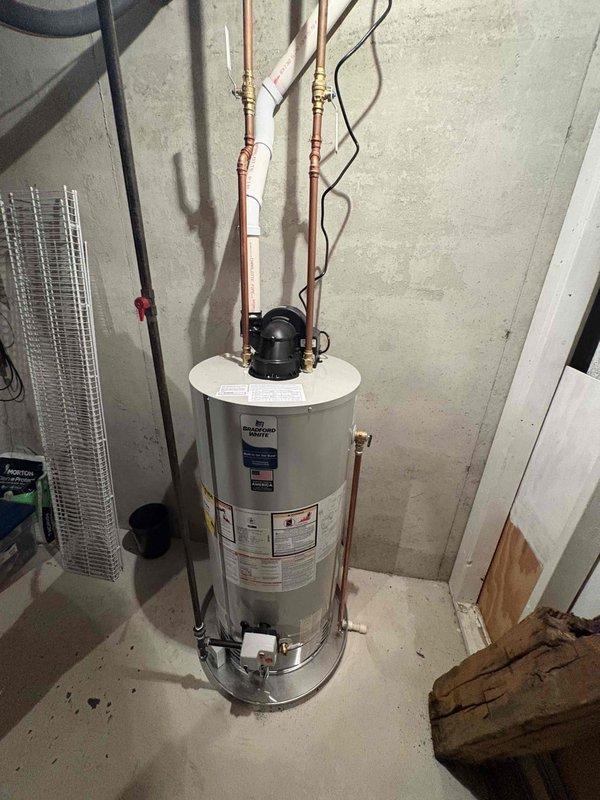 # Water Heater Installation Summary

Successfully completed installation of a 50-gallon Bradford White natural gas water heater with 40,000 BTU input rating. Removed existing unit and installed new AHRI-certified automatic storage water heater with proper copper supply line connections, including installation of heat trap loops on hot water outlet. Unit was positioned on concrete floor with appropriate drip pan, connected to existing gas line, and vented according to manufacturer specifications. All plumbing connections were completed with copper piping, pressure tested for leaks, and system was fired up to verify proper operation of burner assembly and temperature controls.