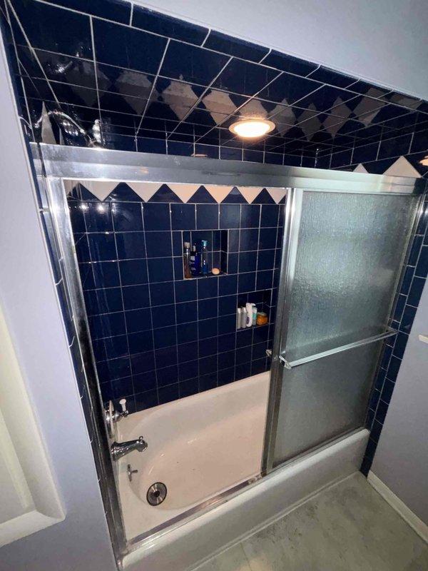 # Job Description

Completed cartridge replacement for shower valve assembly in tiled shower/tub combination. Removed existing worn cartridge from wall-mounted shower control fixture and installed new replacement cartridge to restore proper temperature control and water flow functionality. Verified operation of hot and cold water mixing, tested for leaks at escutcheon plate and valve body connections, and confirmed smooth handle operation. All plumbing fixtures returned to full working order with no drips or leaks detected upon completion.