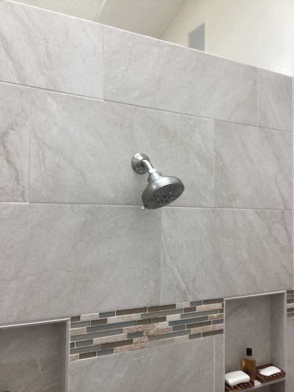 # PRFCT-Faucet Repair Service Report

Completed follow-up shower head replacement to address leaking issue identified during previous service visit. Removed existing chrome shower head fixture and installed new replacement unit on wall-mounted curved arm. Verified proper sealing at wall connection point and tested water flow to confirm leak elimination. All spray nozzles functioning correctly with no drips or water seepage detected upon completion.