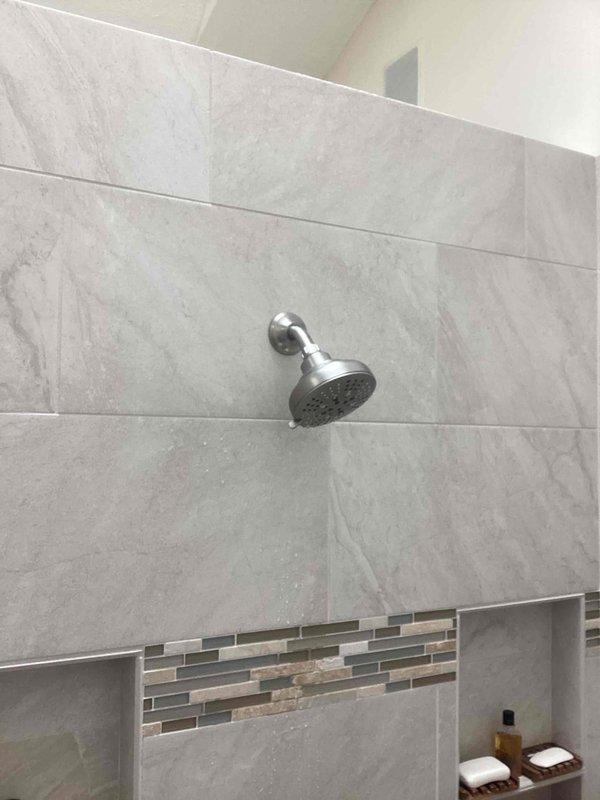 # PRFCT-Faucet Repair Service Report

Completed follow-up shower head replacement to address leaking issue identified during previous service visit. Removed existing chrome shower head fixture and installed new replacement unit on wall-mounted curved arm. Verified proper sealing at wall connection point and tested water flow to confirm leak elimination. All spray nozzles functioning correctly with no drips or water seepage detected upon completion.