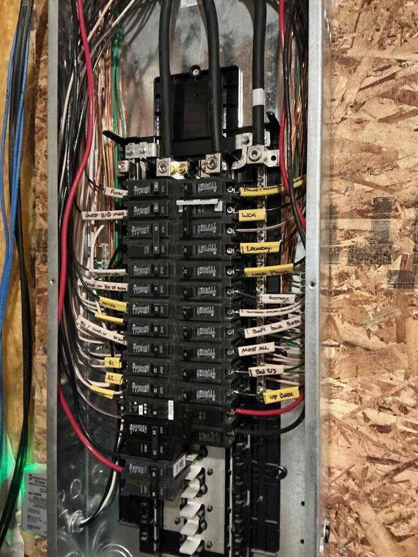 # Electrical Estimate Summary

Completed on-site electrical estimate for portable generator integration and associated wiring requirements. Evaluated existing residential electrical panel configuration, circuit distribution, and available capacity to accommodate generator transfer switch installation. Documented current panel layout showing dual-column breaker arrangement with labeled circuits for kitchen, laundry, bedrooms, and other essential loads. Assessed wire routing pathways, structural access points through OSB sheathing and stud framing, and coordination requirements with existing plumbing and mechanical systems in unfinished interior space to develop comprehensive scope and material requirements for generator connection project.