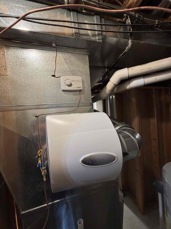 # Humidifier Installation Service Report

Successfully completed installation of residential whole-home humidifier unit in basement mechanical room. Unit was mounted to existing HVAC ductwork and integrated with the forced air system. Made necessary electrical connections for humidifier control and wired to existing thermostat for automated humidity management. Plumbing connections were completed to supply water line using appropriate saddle valve installation on nearby copper piping. Verified proper drainage routing and tested unit operation through complete cycle. All connections were secured and leak-tested. System commissioned and left in operational status with humidity control functioning as designed.