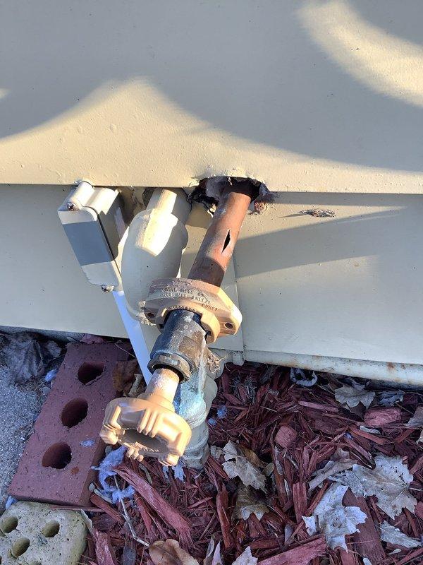 # Plumbing Leak Repair - Exterior Hose Spigot and Related Interior Leaks

Responded to a plumbing leak emergency at a 1955-built residence where an exterior hose spigot had been actively leaking for two days, with associated leaks manifesting inside the home. Upon arrival, performed comprehensive inspection of the exterior wall penetration point and traced the water supply line from the outside spigot through the wall cavity to identify all leak sources.

The exterior hose bib showed signs of valve stem failure and compromised packing, with visible water damage and staining on the white siding surrounding the copper pipe penetration point. The copper supply line exhibited corrosion consistent with the age of the home's original plumbing system. Water infiltration had traveled along the pipe pathway through the exterior wall, causing interior leak issues.

Shut off the main water supply to prevent further water damage. Removed the failed hose spigot assembly and inspected the copper sup