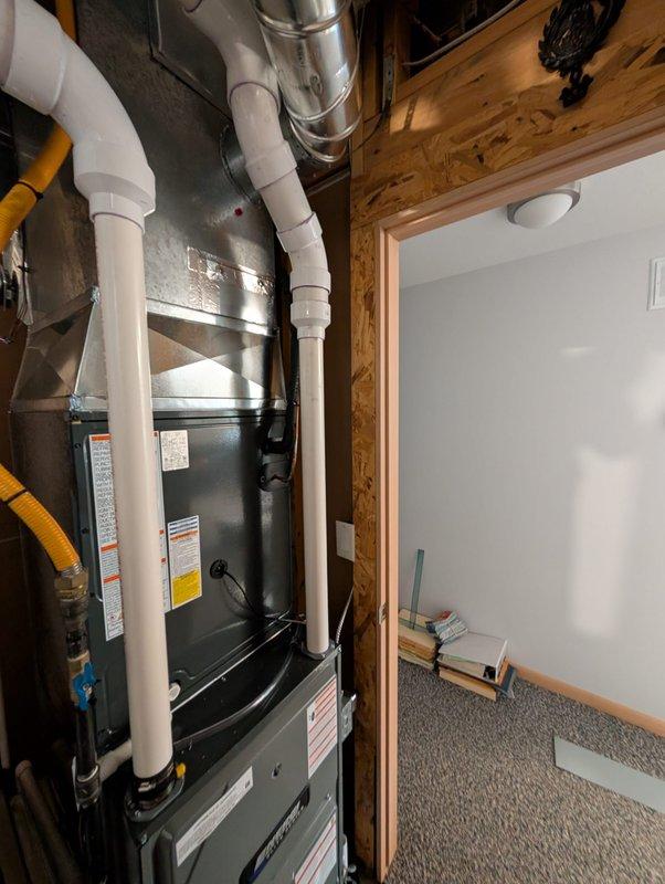 Relocated humidifier unit and associated MC cable in residential mechanical space to optimize system layout and accessibility. Rerouted electrical connections and repositioned equipment while maintaining proper clearances from furnace, ductwork, and gas lines in basement utility area.