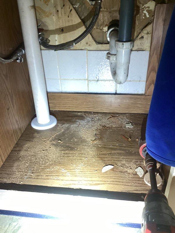 Completed drain repair beneath bathroom vanity involving replacement of deteriorated P-trap assembly and associated drain lines. Removed existing damaged PVC components, installed new P-trap with proper venting connections, and verified all connections for proper seal and drainage flow. Work area cleaned and tested to confirm no leaks and proper operation.